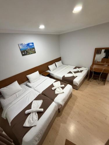 a room with three beds with towels on them at Istanbul Family Apartment in Istanbul