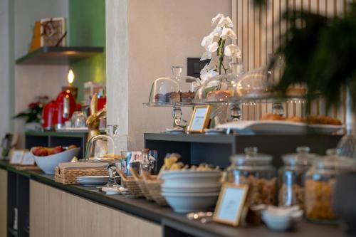 un bufé con platos y cuencos de comida en una barra en Roccaverde Hotel, en Breno