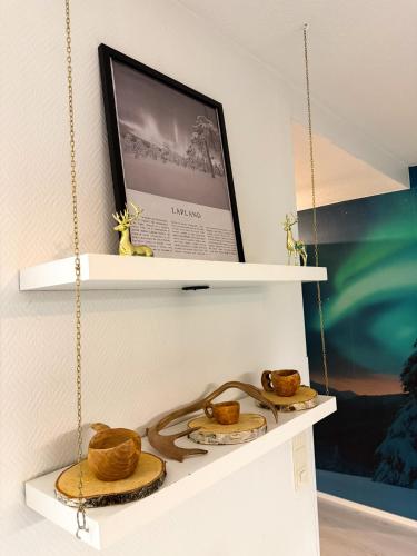 a shelf with baskets and a tv on a wall at Aurora Home Rovaniemi in Rovaniemi