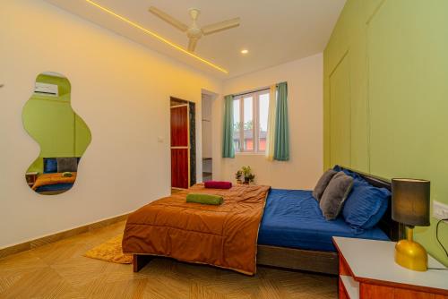 a bedroom with a bed and a ceiling fan at Palmera Home Stay in Siolim