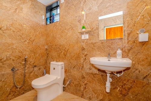 a bathroom with a toilet and a sink at Palmera Home Stay in Siolim