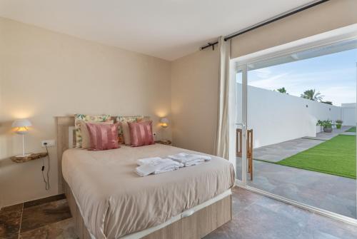 una camera da letto con un letto e una grande finestra di The Suite Villa a Playa Blanca