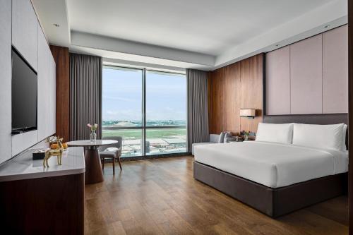 a bedroom with a large bed and a large window at Crowne Plaza Phnom Penh by IHG in Phnom Penh