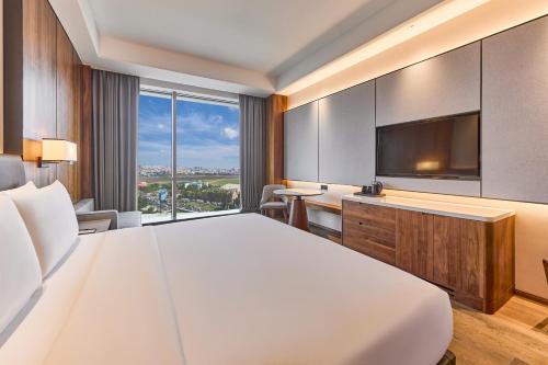 a hotel room with a large bed and a flat screen tv at Crowne Plaza Phnom Penh by IHG in Phnom Penh