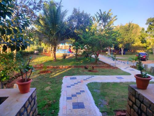 イェーラギリにあるGlass House Yelagiriの木々のある公園と鉢植えの植物が置かれた歩道