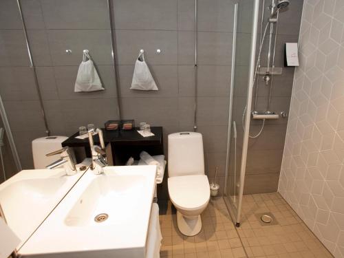 a bathroom with a toilet and a sink and a shower at Original Sokos Hotel Puijonsarvi in Kuopio