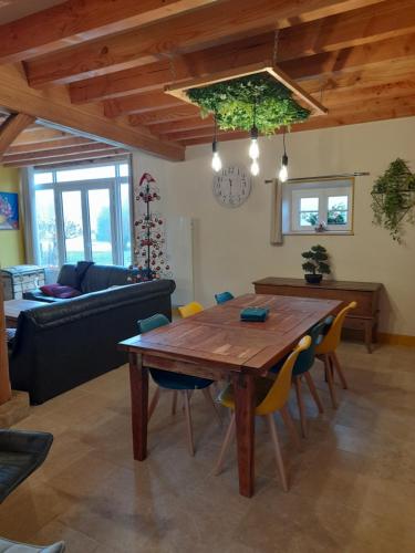 een woonkamer met een houten tafel en stoelen bij La Longère des Oies in La Celle-sous-Gouzon