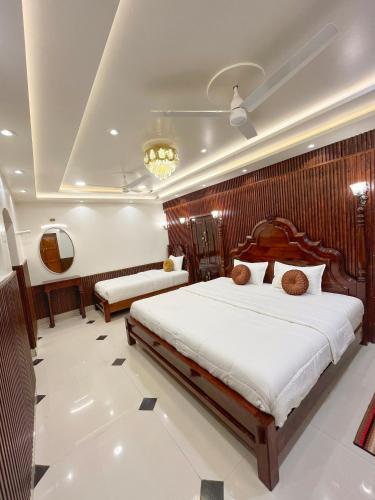a bedroom with two beds in a room at Shree Jyotirlinga Heritage INN in Kolhapur