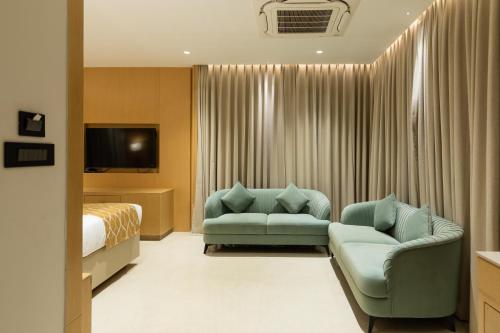 a hotel room with a couch and a bed at JALSA HOTEL & BANQUETS,Indore in Indore