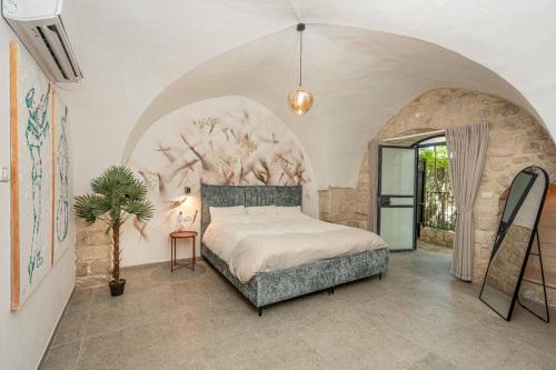 a bedroom with a large bed in a room with an arch at Moses Luxury apartments 36 a in Safed