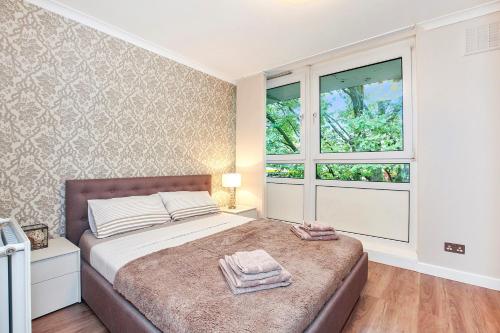 sypialnia z łóżkiem z dwoma ręcznikami w obiekcie Sach's 2 Bedrooms Apartment - No lift w Londynie