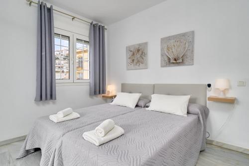 een slaapkamer met een groot bed met twee handdoeken erop bij Apto 3 Almoraide Suites in Nerja