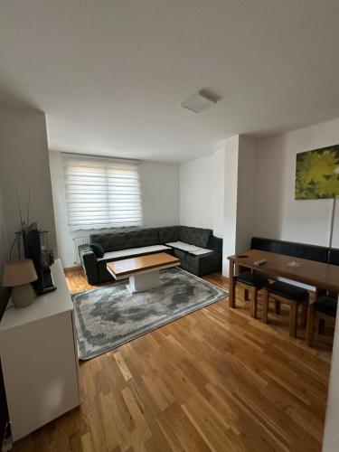 een woonkamer met een bank en een tafel bij Apartman Ranija in Rožaje