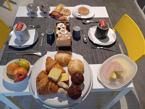 - une table avec des assiettes de produits pour le petit-déjeuner dans l'établissement B&B Giolì, à Milan