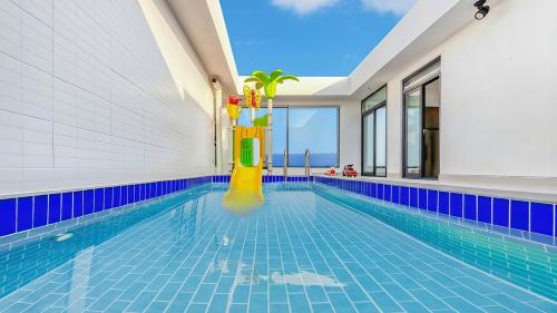 an infinity pool with a pool house with a swimming pool at Goseong Belossi Ayajin Kids Poolvilla in Goseong