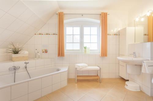 a white bathroom with a tub and a sink at Haus Eichenwald in Glowe