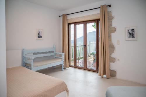 1 dormitorio con puerta corredera que da a un balcón en Elia, en Kavoúsion