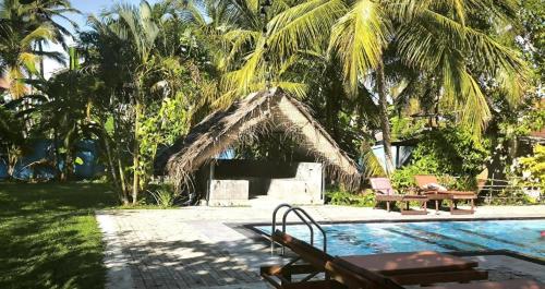 un complexe hôtelier avec piscine et maison dans l'établissement Papaya Hikkaduwa, à Hikkaduwa