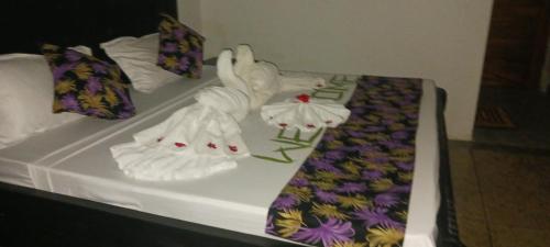 a bed with two white swans on it at TheChef NungwiBungalow in Kidoti