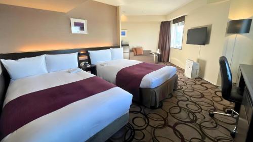 a hotel room with two beds and a television at ANA Crowne Plaza Hotel Kushiro by IHG in Kushiro