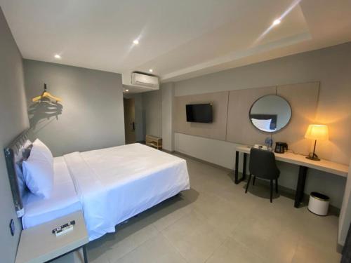 a bedroom with a bed and a desk and a mirror at MBS HOTEL Medan in Medan