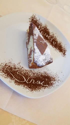a piece of cake on a plate with chocolate at Hotel Monte Sirai in Carbonia