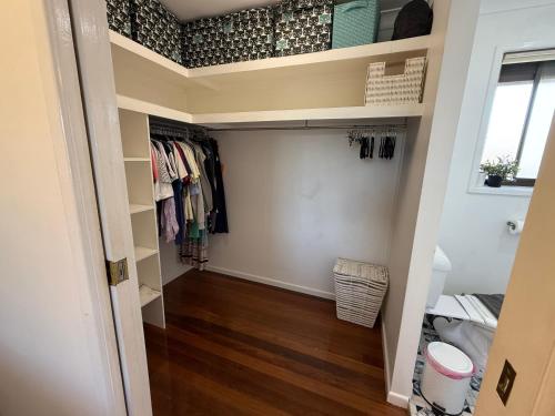 een inloopkast met houten vloeren en planken bij 4BR big family house with huge pool in Brisbane