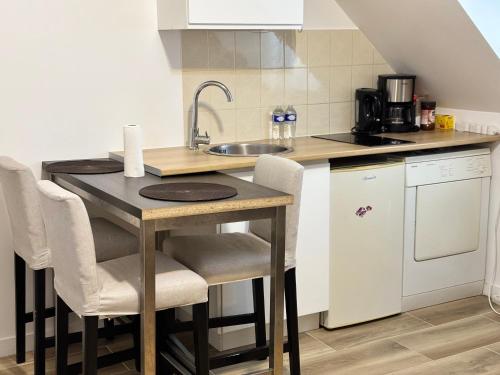 a kitchen with a table with chairs and a sink at Super appartement in Malesherbes