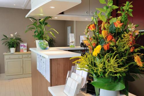 a flower shop with a counter with vases of flowers at Campanile Valence Sud in Valence