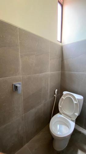 a bathroom with a white toilet and a window at First Kost Seturan 32 in Yogyakarta