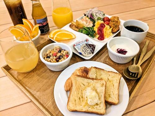 uma mesa com um prato de comidas e bebidas para o café da manhã em Green Rich Hotel Tokuyama Ekimae em Shunan