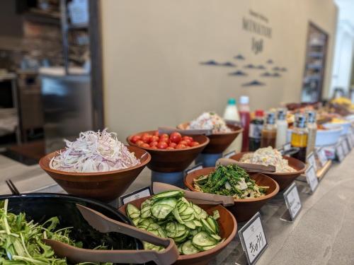 uma exibição de tigelas de vegetais num balcão em Green Rich Hotel Tokuyama Ekimae em Shunan