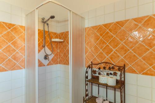 um chuveiro na casa de banho com azulejos laranja e branco em Pupureddu con Terrazza ad Olbia em Olbia