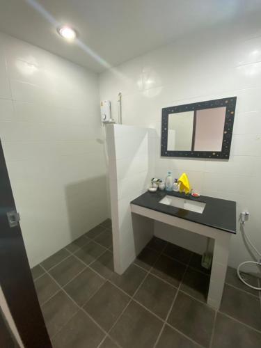 ein Badezimmer mit Waschbecken und Spiegel in der Unterkunft Baan Rungrojn HuaHin in Hua Hin