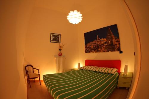 マテーラにあるLa Casetta del Vicinatoのベッドルーム1室(緑と白の毛布付きのベッド1台付)