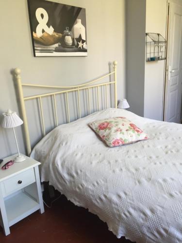 a bedroom with a white bed with a pillow on it at Maison d'Hôtes La Bastide Bleue in Marseille