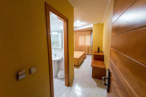 a room with a bathroom with a sink and a toilet at Hotel Dinajan in Villanueva de Arosa