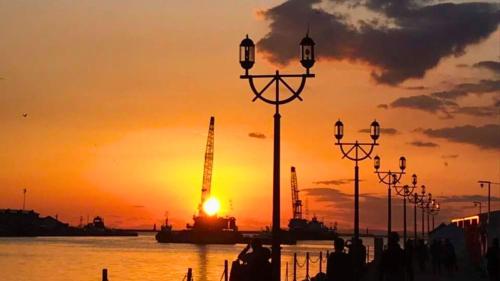 Una puesta de sol sobre el agua con una hilera de farolas en ANA Crowne Plaza Hotel Kushiro by IHG, en Kushiro