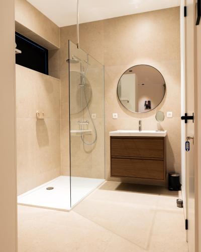 a bathroom with a shower and a sink and a mirror at Bocca in Hasselt