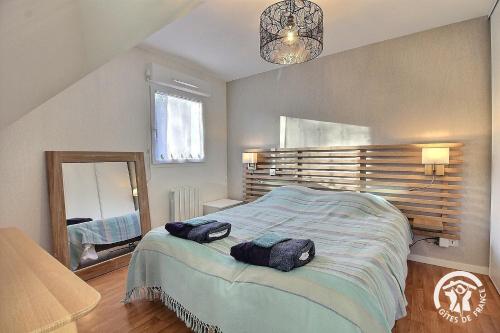 a bedroom with a large bed with two bags on it at Le balcon de la baie in Paimpol