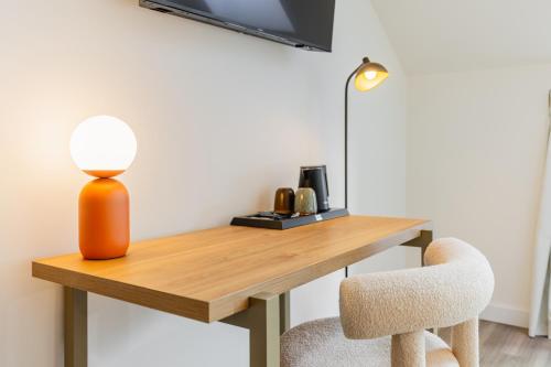a desk with a lamp and a chair at FortyPlusOne Hotel Vienna in Vienna