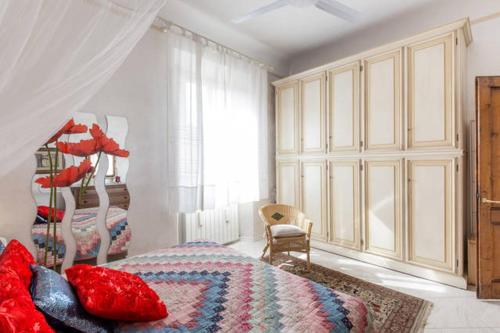 sypialnia z łóżkiem z czerwonymi poduszkami w obiekcie Oasi di pace we Florencji
