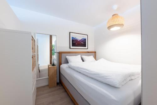 a bedroom with a bed with white sheets at Apartment Tinus - 3 min Walk to Ski Lift in St. Moritz