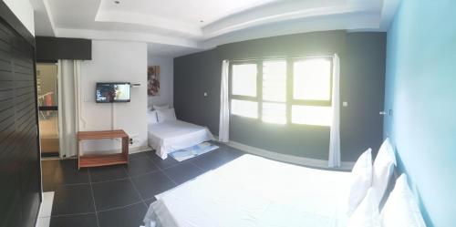 a small room with a bed and a window at "FLORIDA" - Guest-house Tamatave in Toamasina