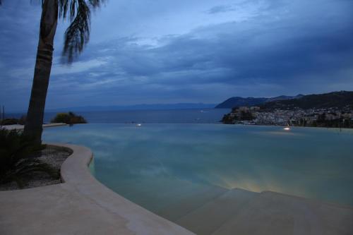a swimming pool with a view of the ocean at night at Hotel Villa Enrica - Aeolian Charme in Lipari