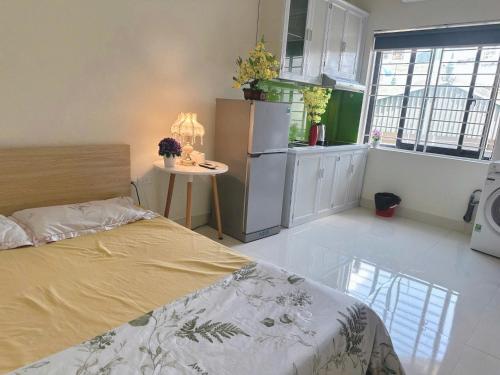 a bedroom with a bed and a kitchen with a refrigerator at Phương Đông 502DT in Hanoi