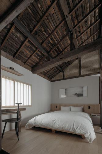 a bedroom with a large bed and a desk at Haku-ma 白間 in Kanazawa