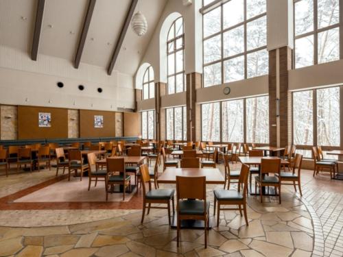 a dining room with tables and chairs and windows at Chez-soi Wakamiya in Gujo