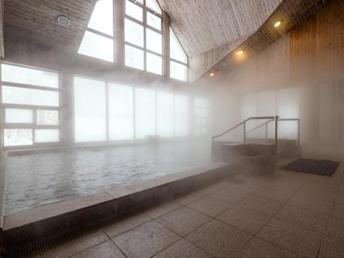 a pool of water in a room with windows at Chez-soi Wakamiya in Gujo