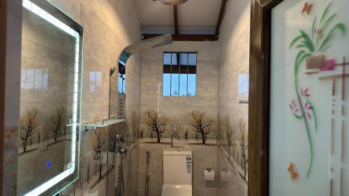 een badkamer met een toilet met bomen aan de muur bij Villa A7 in Ahangama
